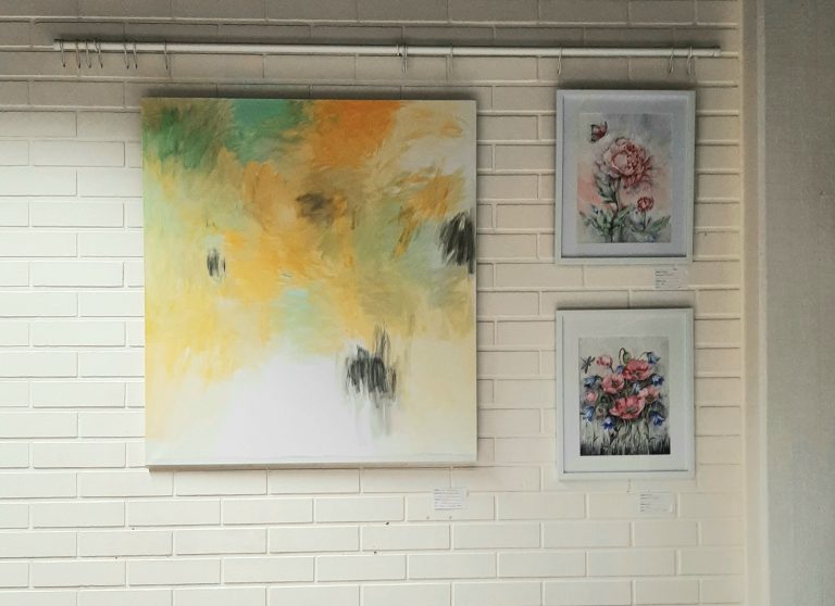 Kolme taulua esillä kirjaston kahvilan seinällä